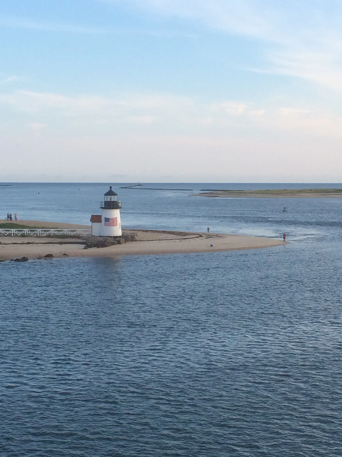 Brant Point Light on its low sand spit at the Nantucket harbor entrance — the calm, low-lying shoreline where the island's flood zones concentrate
