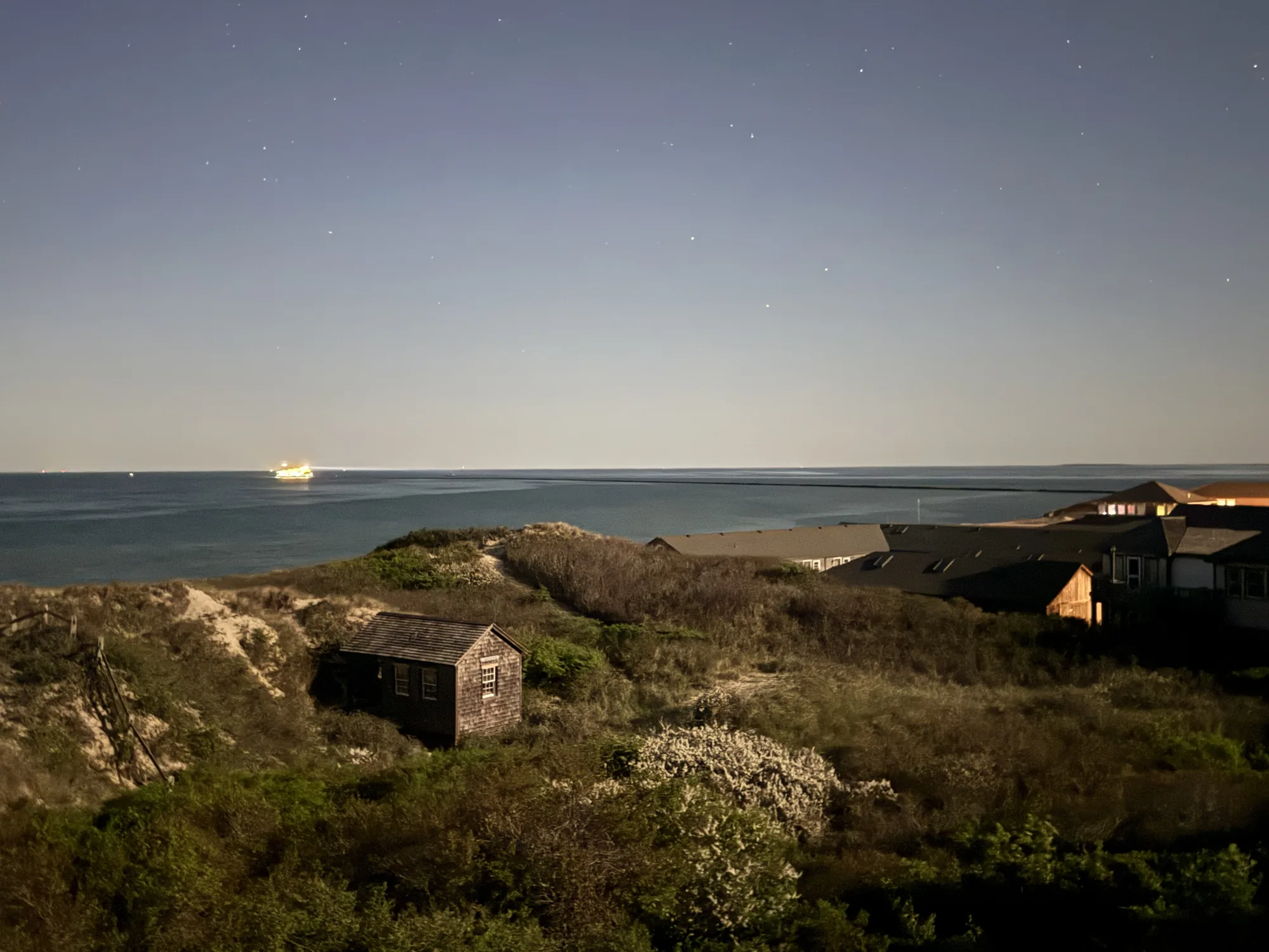Dusk over the dunes and a shingled cottage toward the water in the Cliff area of Nantucket