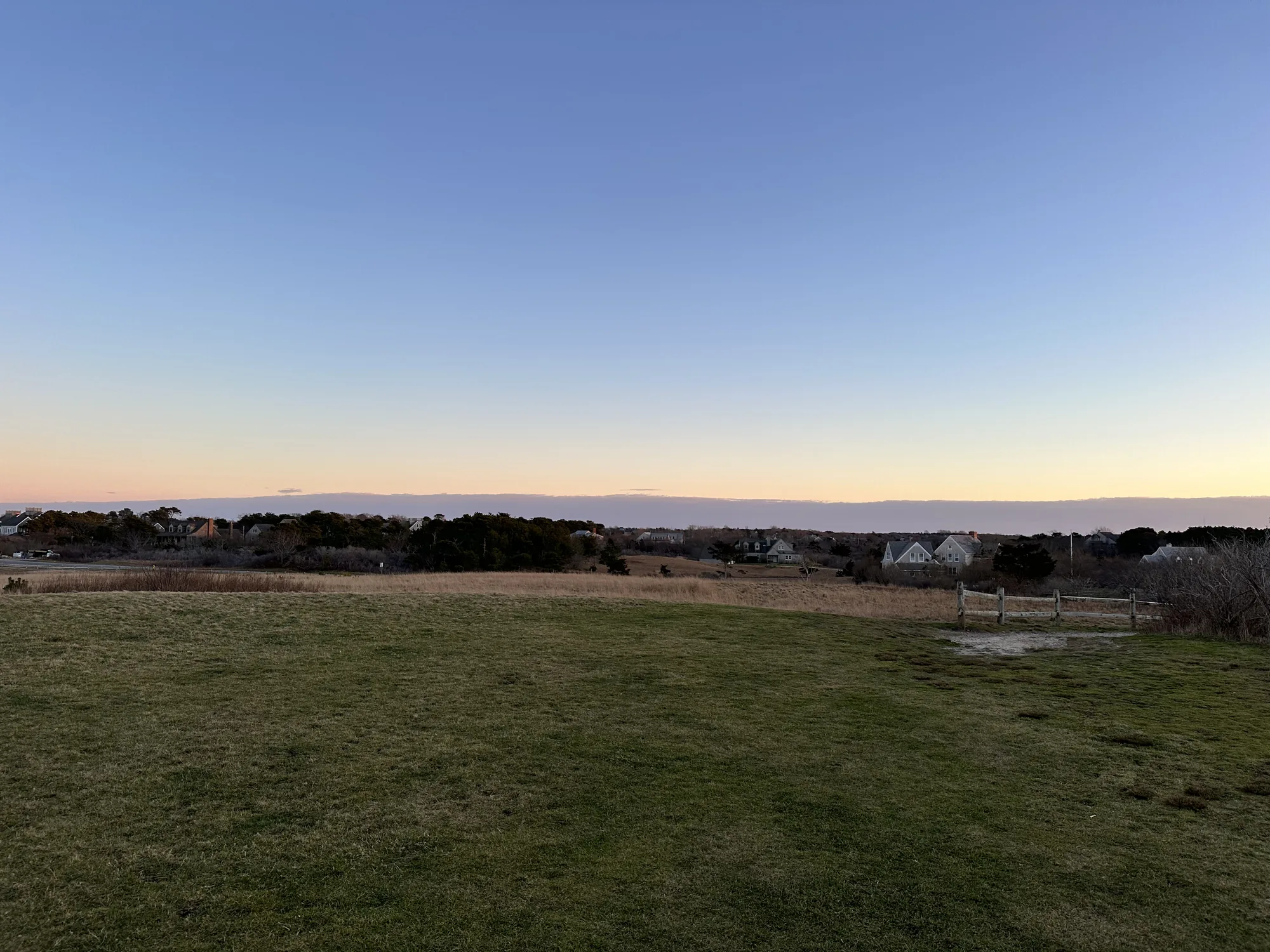 Open lawn running toward Nantucket Sound at dusk at Tupancy Links in the Cliff Road area of Nantucket