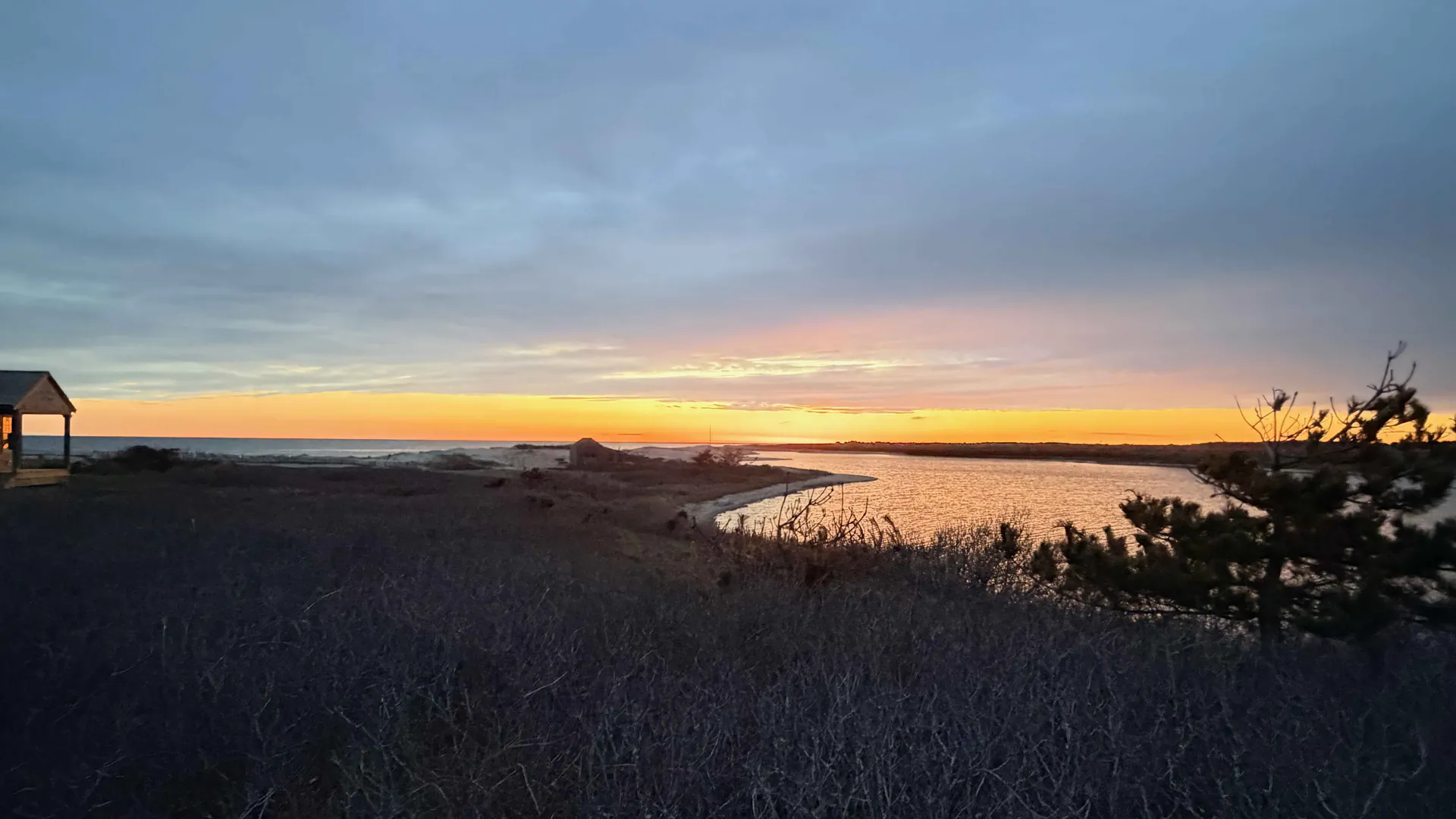 Sunset over Hummock Pond, Nantucket, with the shore and dune scrub in the foreground