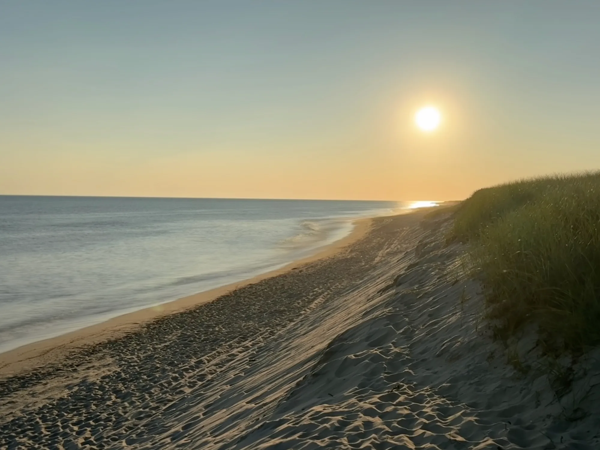 Sunset over the south shore beach and dunes at the ocean end of Hummock Pond on Nantucket
