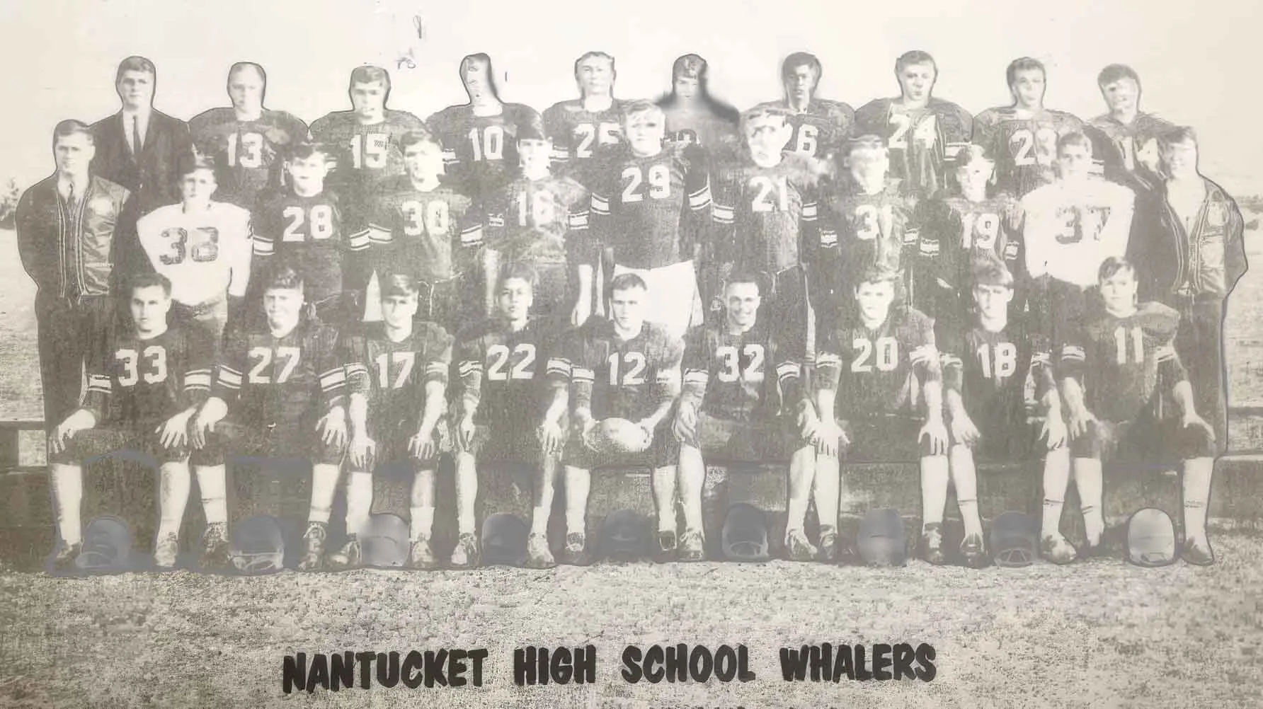 A 1960s Nantucket High School Whalers football team photograph: three rows of players in numbered jerseys with their coaches, helmets lined up on the grass in front, from a vintage black-and-white print