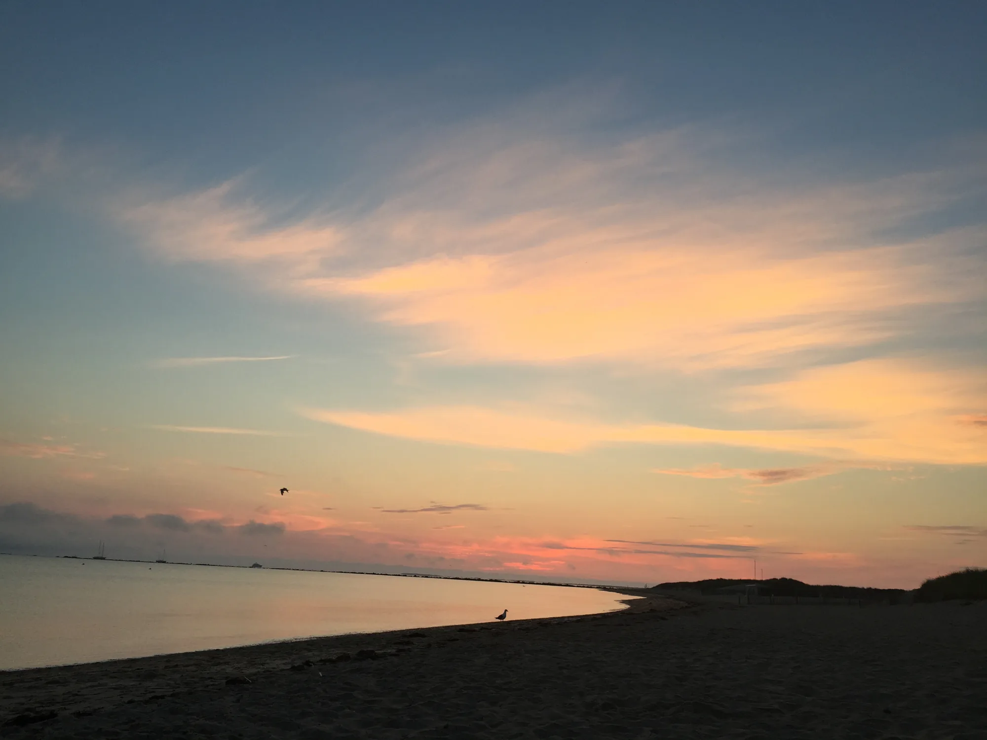 Nantucket vacation home at sunset on a calm harbor beach