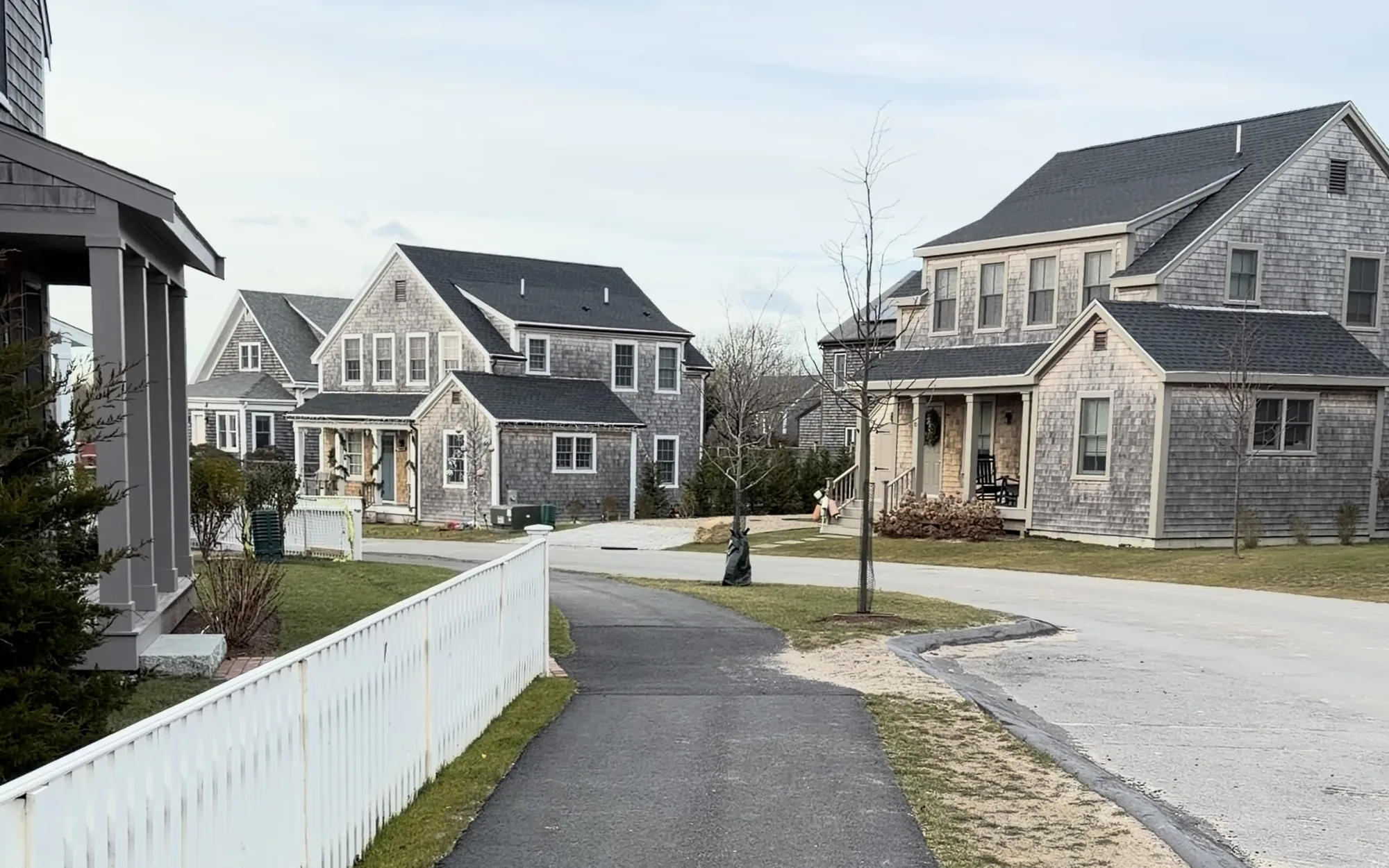 Gray-shingled homes and a white picket fence along the lane at Sandpiper Place on Nantucket