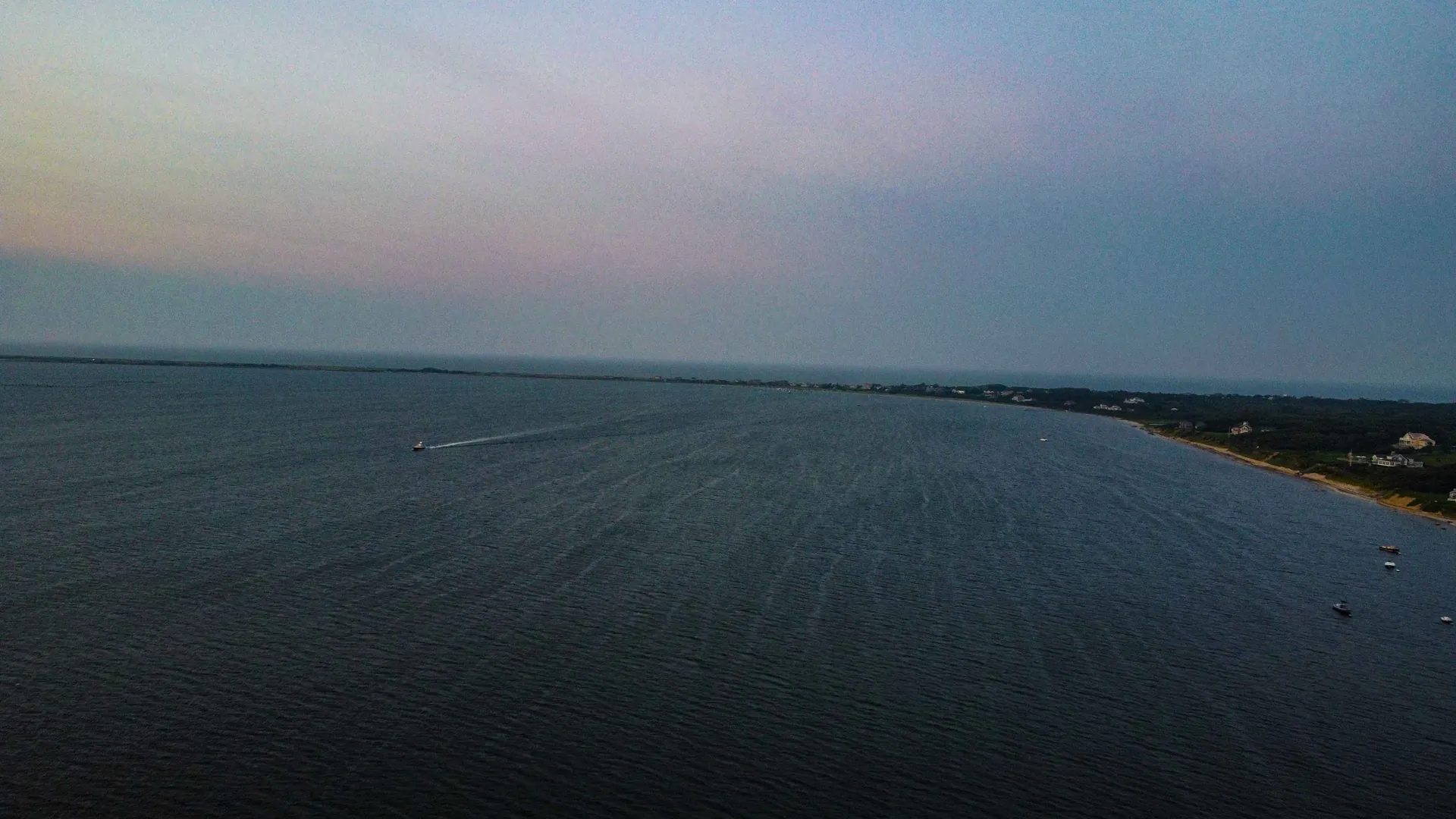 Nantucket Harbor at dusk from Wauwinet, looking down the shoreline toward the point